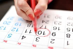 Woman circling date on calendar