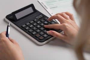 Woman typing on calculator