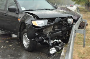 black car crunched into guardrail