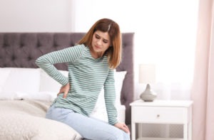 young woman suffering with back pain