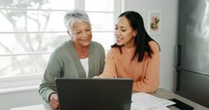 Kitchen,,Mother,And,Woman,With,Laptop,For,Finance,,Track,Expenses