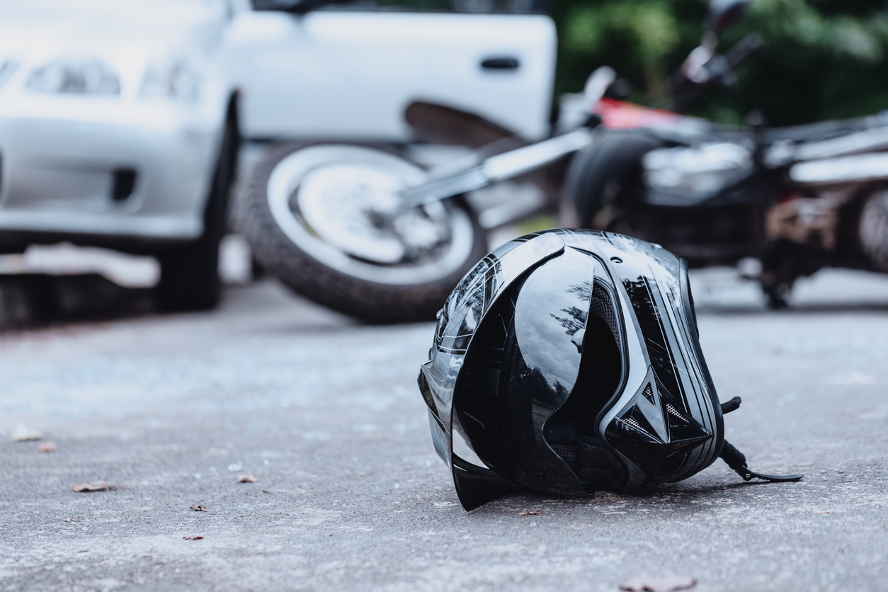 Motorcycle and car crash, with a motorbike helmet on the ground